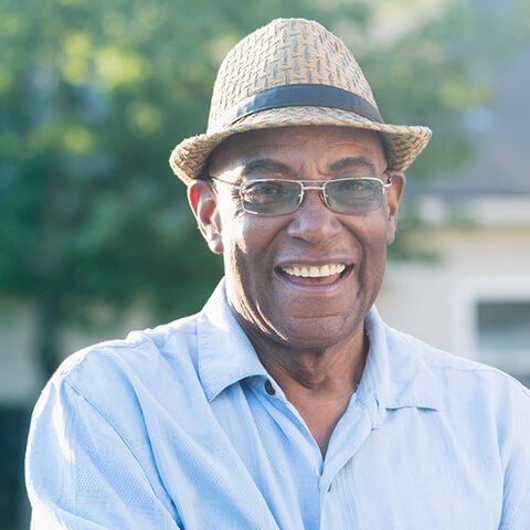 Older male with a fedora hat, smiling in the sun thanks to restorative dentistry from his dentist in Lititz, PA Dr. Richard M Berg. 